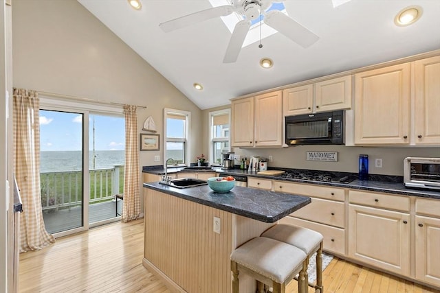 125 Seaview Dr, Plymouth, MA 02360 - kitchen featuring an island with sink, gas stovetop, plenty of natural light, light brown cabinetry, and black microwave