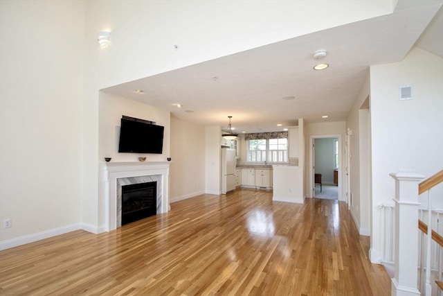 6 State Park Rd Unit 2, Hull, MA 02045 - unfurnished living room featuring light wood-type flooring, a high end fireplace, baseboards, and recessed lighting