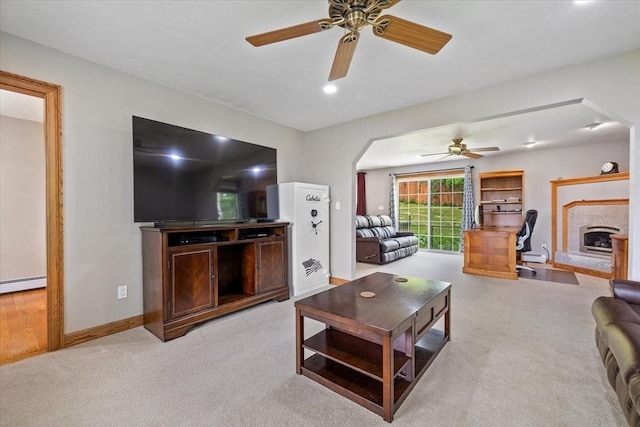447 Coy Hill Rd, Warren, MA 01083 - living room featuring a ceiling fan, a high end fireplace, light carpet, a baseboard heating unit, and arched walkways