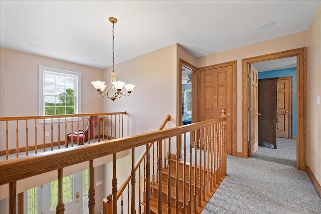 447 Coy Hill Rd, Warren, MA 01083 - hallway featuring an upstairs landing, light colored carpet, a chandelier, and baseboards