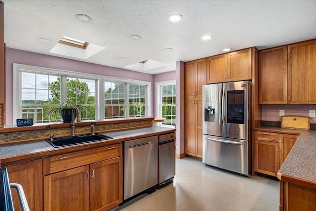 447 Coy Hill Rd, Warren, MA 01083 - kitchen with stainless steel appliances, a sink, a skylight, brown cabinetry, and recessed lighting
