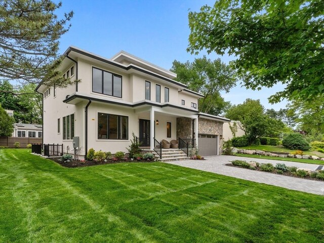 55 June Ln, Newton, MA 02459 - view of front of house with decorative driveway, stucco siding, stone siding, central AC unit, and an attached garage