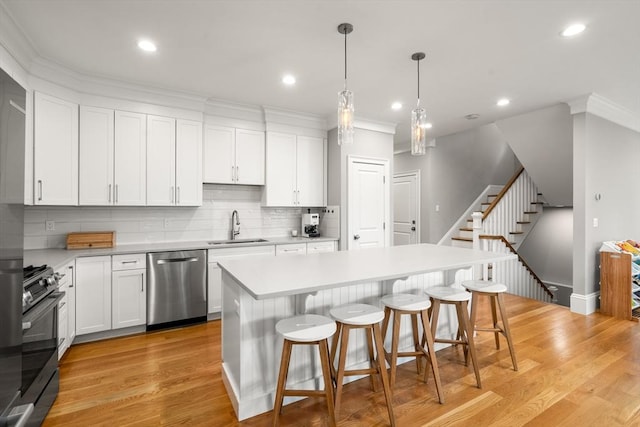 2 Rockwood Ter Unit 2, Newton, MA 02466 - kitchen with stainless steel appliances, a sink, light countertops, a kitchen breakfast bar, and a center island