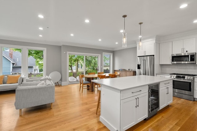 2 Rockwood Ter Unit 2, Newton, MA 02466 - kitchen featuring appliances with stainless steel finishes, beverage cooler, ornamental molding, recessed lighting, and white cabinets