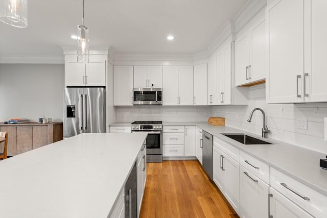 2 Rockwood Ter Unit 2, Newton, MA 02466 - kitchen featuring stainless steel appliances, a sink, crown molding, light countertops, and tasteful backsplash