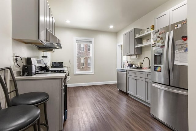 130 Glenville Ave, Boston, MA 02134 - kitchen featuring appliances with stainless steel finishes, gray cabinetry, dark wood-type flooring, under cabinet range hood, and recessed lighting