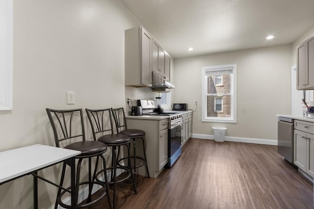130 Glenville Ave, Boston, MA 02134 - kitchen with appliances with stainless steel finishes, under cabinet range hood, dark wood-style floors, gray cabinets, and recessed lighting