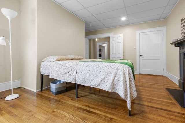 130 Glenville Ave, Boston, MA 02134 - bedroom with wood finished floors, a paneled ceiling, and a fireplace with flush hearth