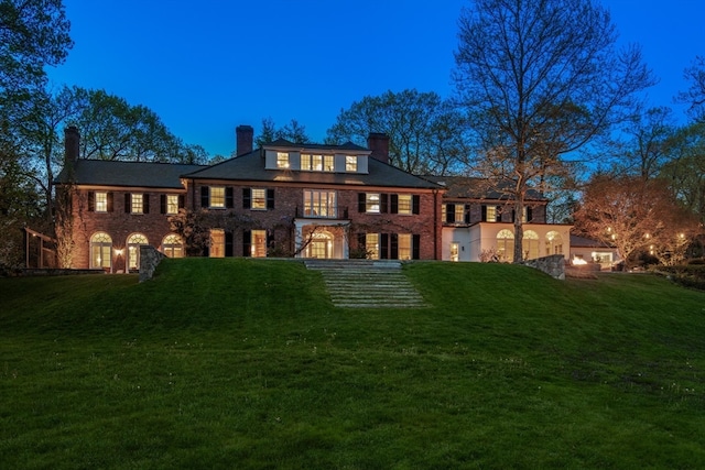 rear view of house featuring a lawn