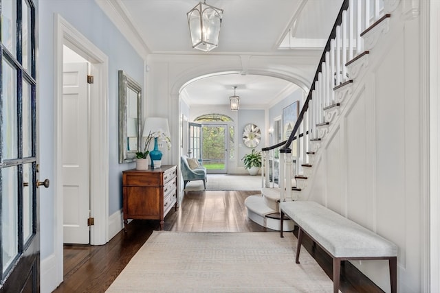 entrance foyer with a chandelier, hardwood / wood-style flooring, and ornamental molding