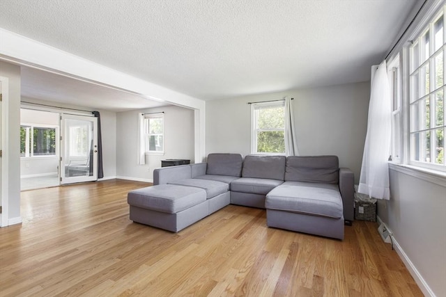 7 Cornish St, Carver, MA 02330 - living room featuring light wood finished floors, a textured ceiling, plenty of natural light, and baseboards