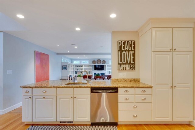 kitchen with light stone counters, stainless steel dishwasher, light wood-style floors, a sink, and recessed lighting