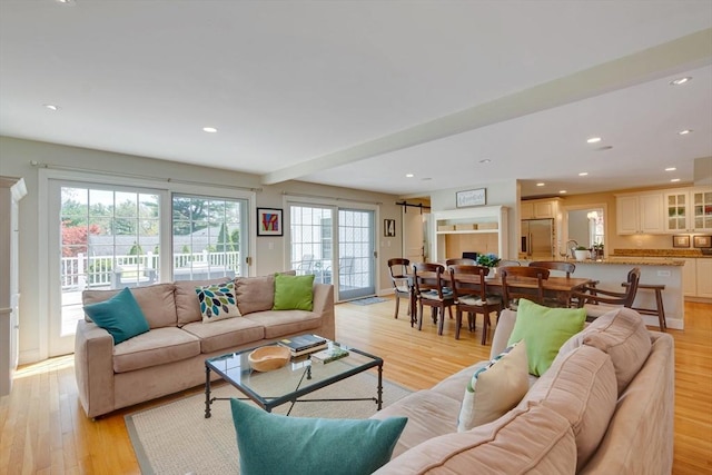 living area featuring light wood-type flooring and recessed lighting