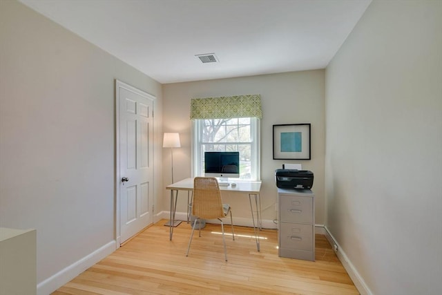 office featuring light wood finished floors, visible vents, and baseboards