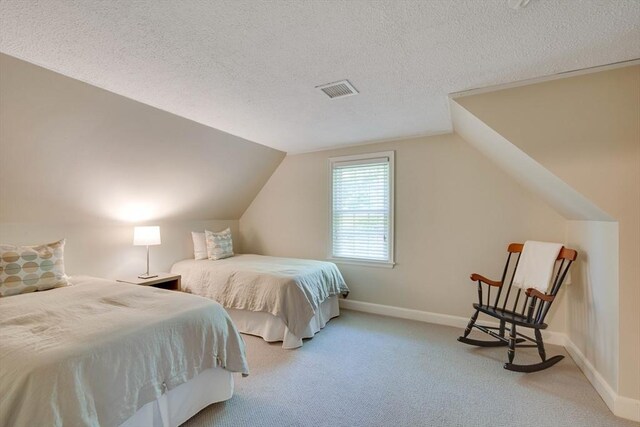 bedroom featuring a textured ceiling, carpet flooring, lofted ceiling, and baseboards