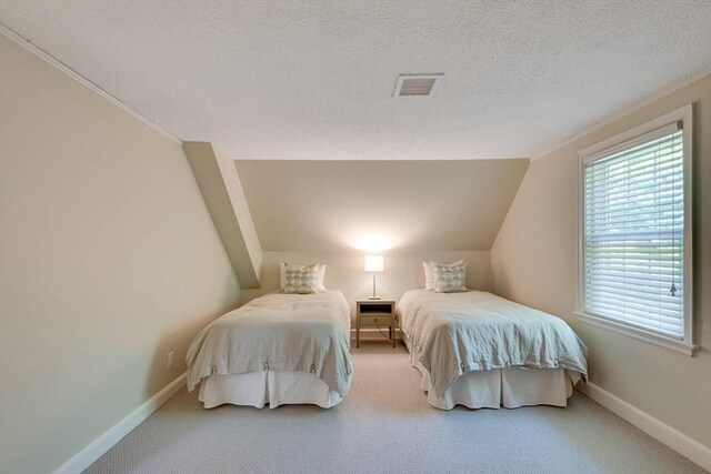 carpeted bedroom featuring a textured ceiling, vaulted ceiling, visible vents, and baseboards