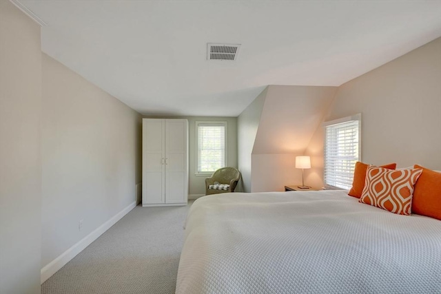 bedroom featuring baseboards, multiple windows, visible vents, and light colored carpet