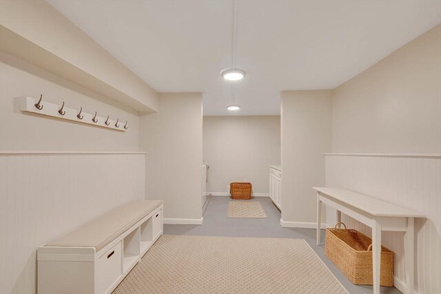 mudroom with a wainscoted wall, carpet, and baseboards