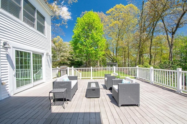 deck featuring an outdoor living space with a fire pit