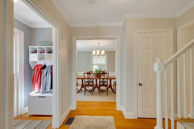 interior space with light wood-style floors, visible vents, crown molding, and baseboards