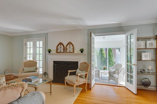 living area featuring a fireplace with flush hearth, french doors, plenty of natural light, and wood finished floors