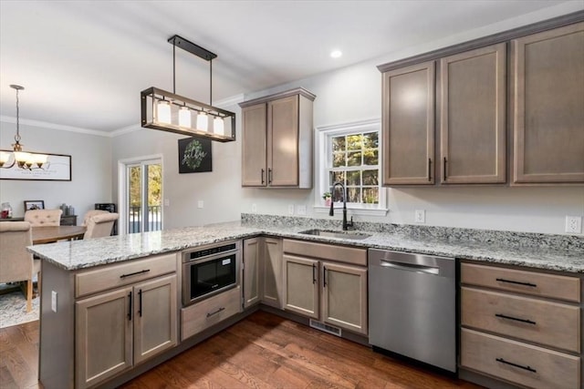 kitchen featuring kitchen peninsula, hanging light fixtures, light stone countertops, sink, and stainless steel dishwasher