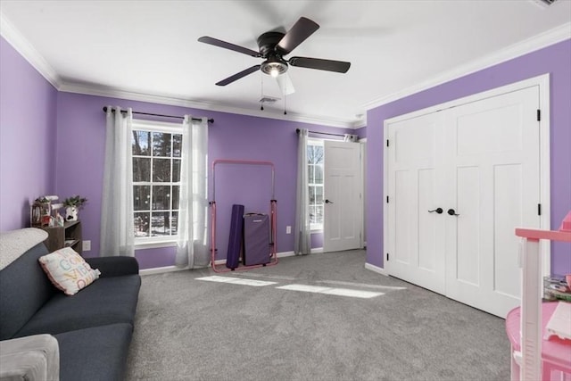 carpeted bedroom with ceiling fan, crown molding, and a closet