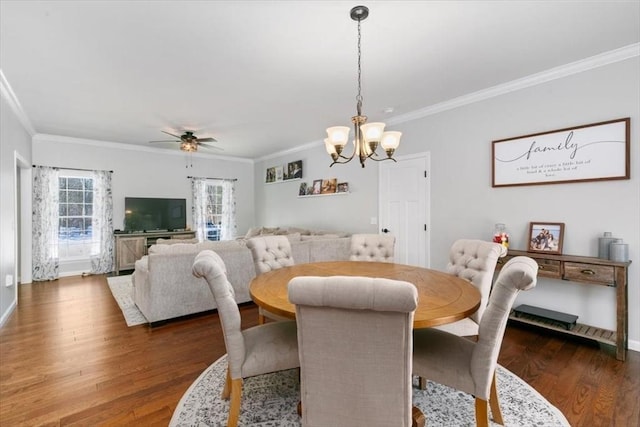 dining room with ceiling fan with notable chandelier, dark wood-type flooring, and crown molding