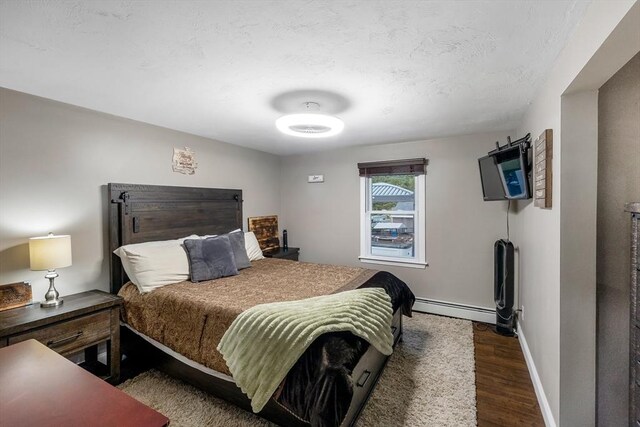 8 New Spencer Rd, Charlton, MA 01507 - bedroom with a baseboard radiator, wood finished floors, baseboards, and a textured ceiling
