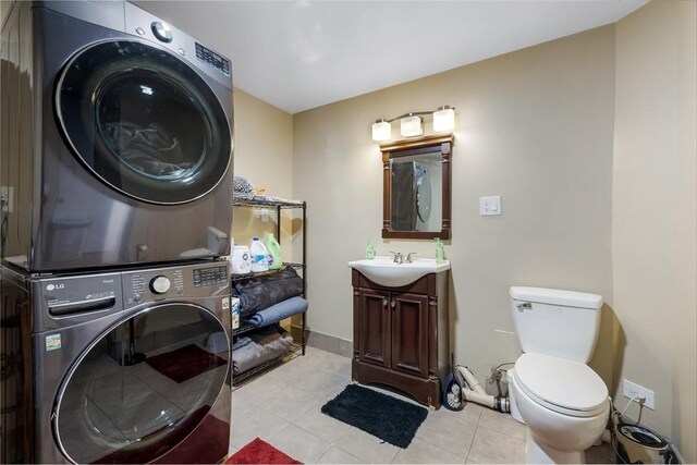 8 New Spencer Rd, Charlton, MA 01507 - bathroom featuring stacked washing machine and dryer, toilet, tile patterned flooring, baseboards, and vanity