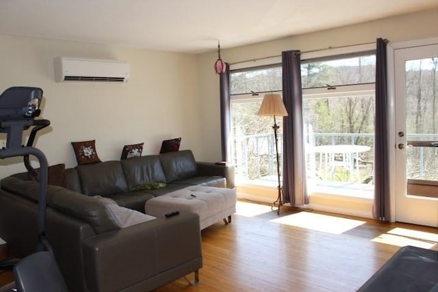 living area featuring plenty of natural light, a wall mounted AC, and wood finished floors