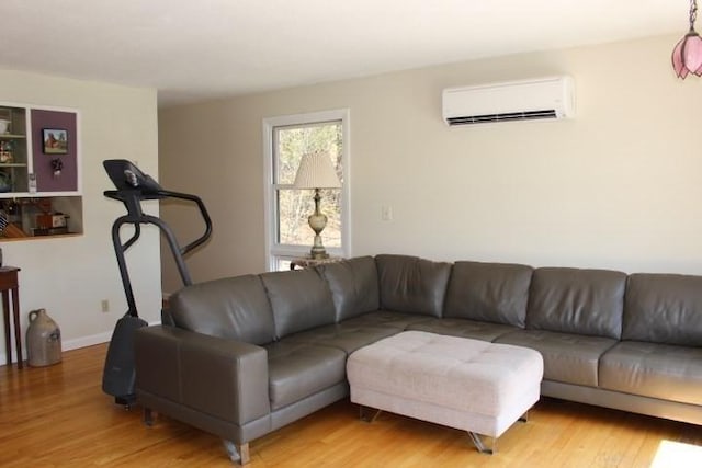 living room with a wall unit AC and wood finished floors