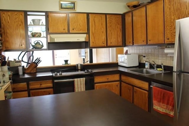 kitchen with tasteful backsplash, a sink, white microwave, under cabinet range hood, and black range with electric cooktop