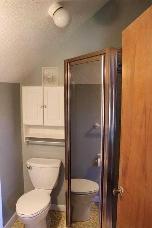 bathroom featuring toilet, a textured ceiling, lofted ceiling, visible vents, and a stall shower