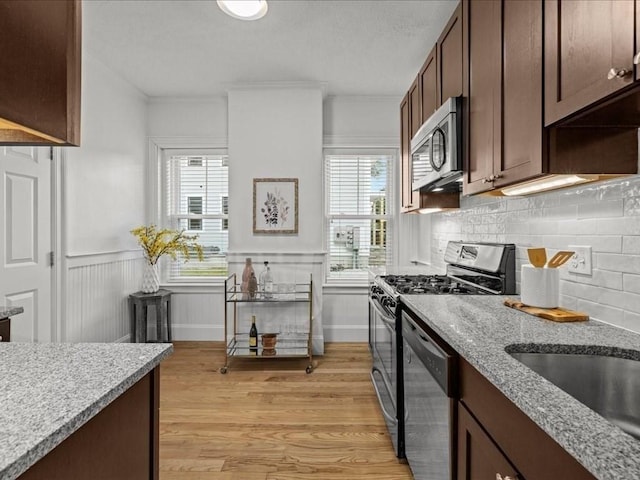 1 Auburn Ct Unit 1, Brookline, MA 02446 - kitchen with appliances with stainless steel finishes, healthy amount of natural light, light wood-type flooring, decorative backsplash, and wainscoting
