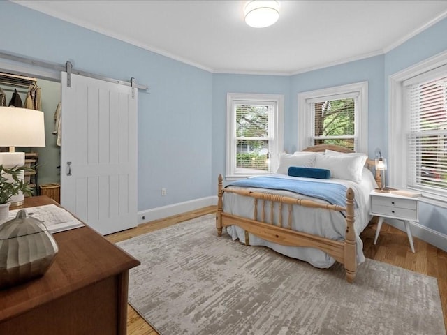 1 Auburn Ct Unit 1, Brookline, MA 02446 - bedroom with ornamental molding, baseboards, light wood finished floors, and a barn door