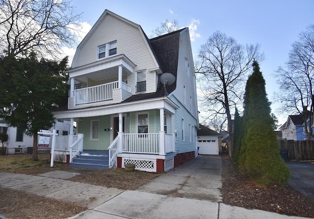 view of front of property with a balcony, covered porch, an outdoor structure, and a garage