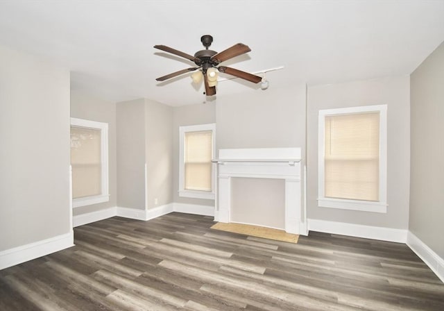 unfurnished living room featuring ceiling fan and dark hardwood / wood-style flooring