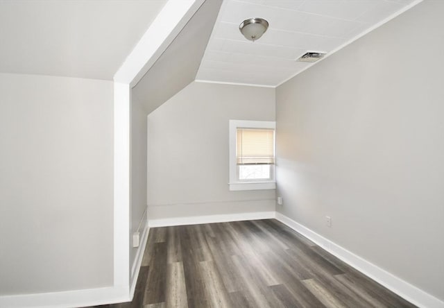 additional living space with dark hardwood / wood-style flooring and vaulted ceiling