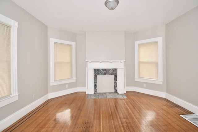 unfurnished living room with a premium fireplace and light hardwood / wood-style flooring