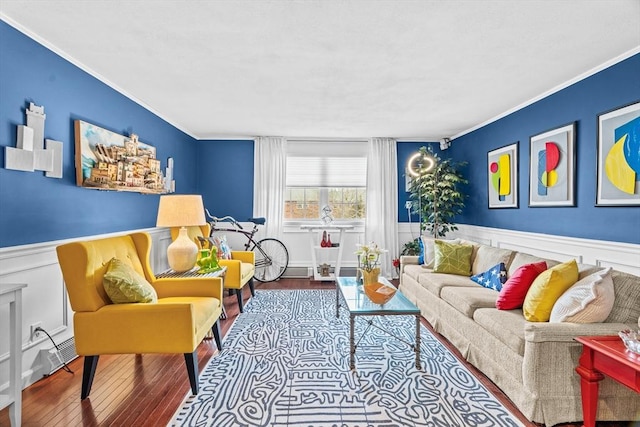 living room with ornamental molding, a wainscoted wall, and wood finished floors