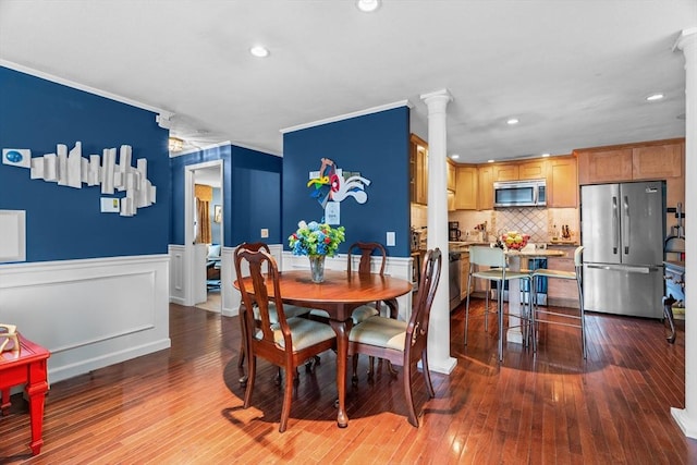 dining area with hardwood / wood-style flooring, wainscoting, decorative columns, and recessed lighting