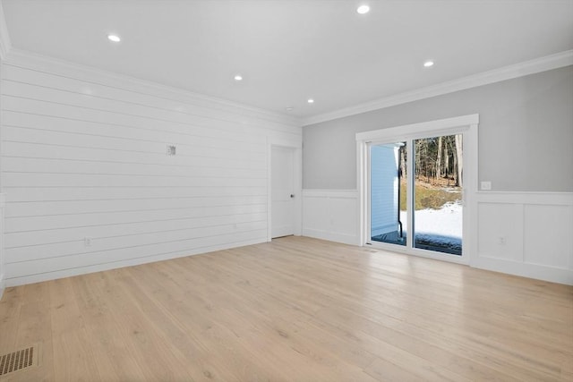 empty room featuring light hardwood / wood-style floors and ornamental molding