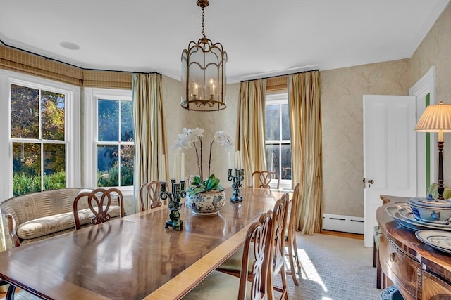 dining room featuring ornamental molding, a notable chandelier, carpet floors, and a baseboard heating unit