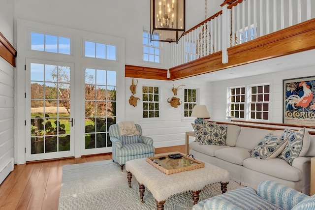 living room featuring hardwood / wood-style floors, a high ceiling, and a notable chandelier