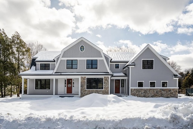 shingle-style home featuring stone siding and a gambrel roof