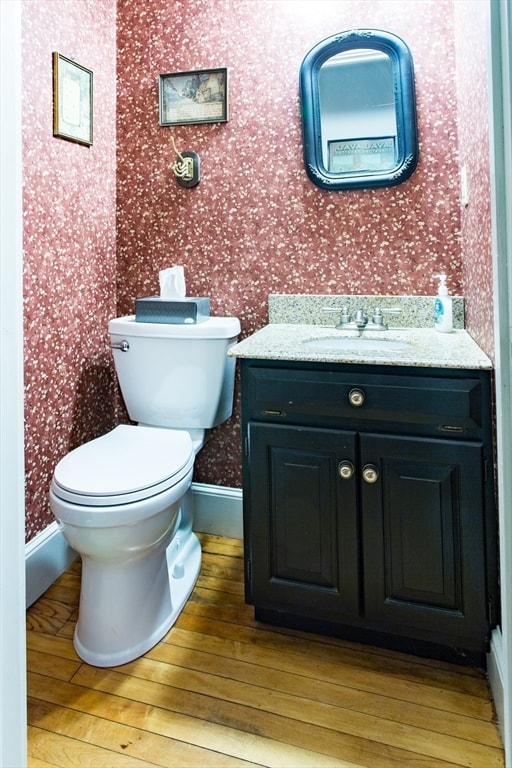 bathroom featuring toilet, vanity, and hardwood / wood-style floors