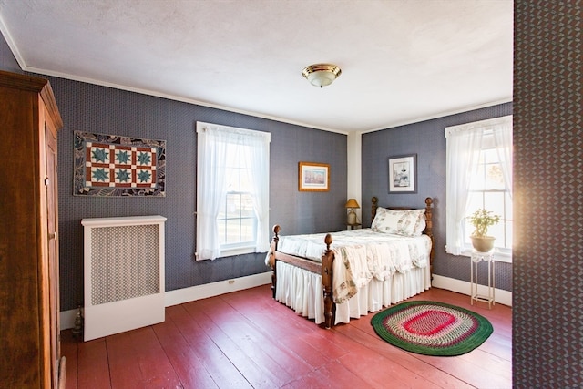 bedroom with radiator heating unit, wood-type flooring, and crown molding