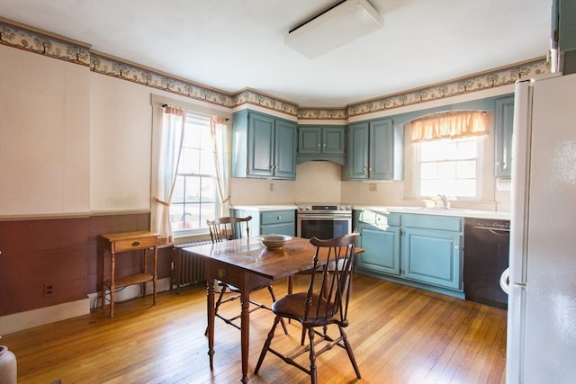 kitchen featuring stainless steel electric stove, white fridge, light wood-type flooring, and dishwasher