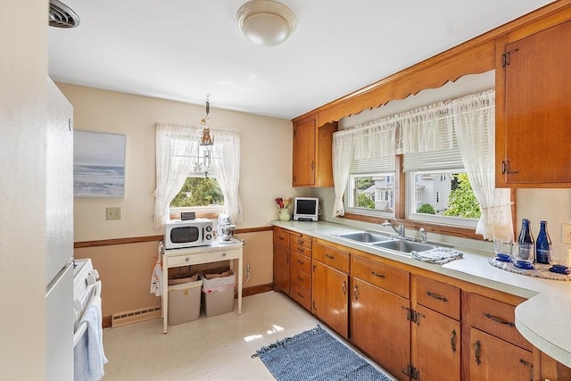 890 Westford St, Lowell, MA 01850 - kitchen with white microwave, light countertops, healthy amount of natural light, and brown cabinets